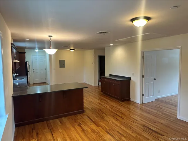 a view of kitchen with refrigerator microwave and wooden floor