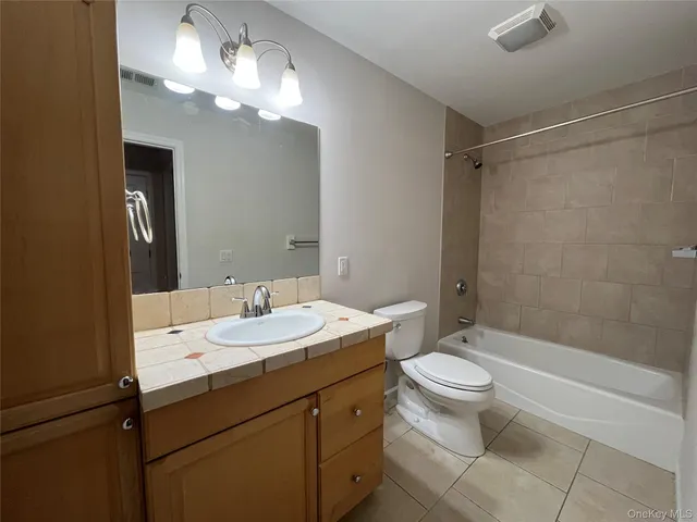 a bathroom with a double vanity sink mirror and toilet