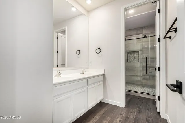 a bathroom with a double vanity sink a mirror and shower