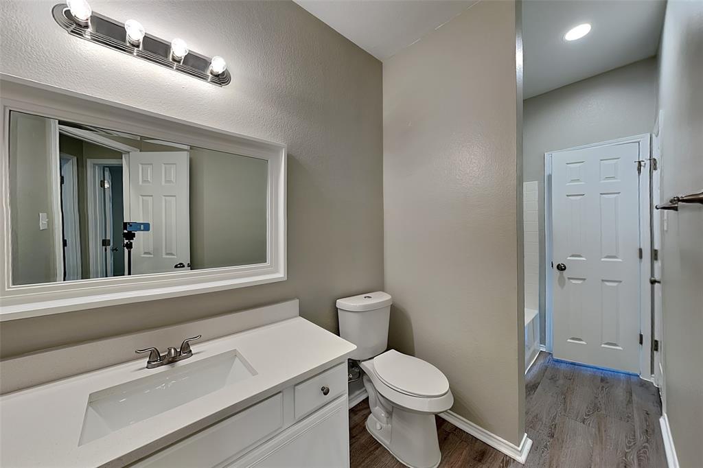 7016 Raintree Way Denton, TX 76210 - Photo 16 of 18 a bathroom with a sink a toilet and a mirror