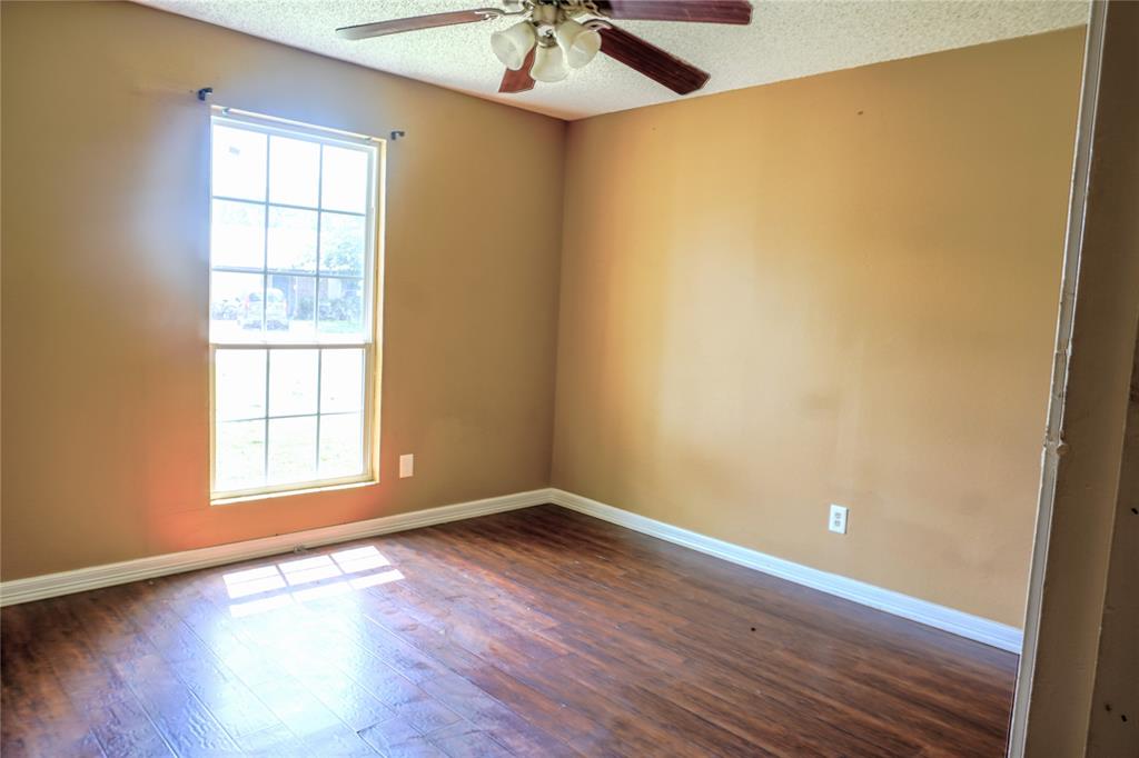 300 Coury Road Everman, TX 76140 - Photo 15 of 29 an empty room with a window and wooden floor