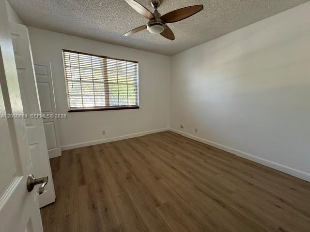 192 Southwest 96th Avenue, Unit 192 Plantation, FL 33324 - Photo 12 of 15 an empty room with wooden floor and windows
