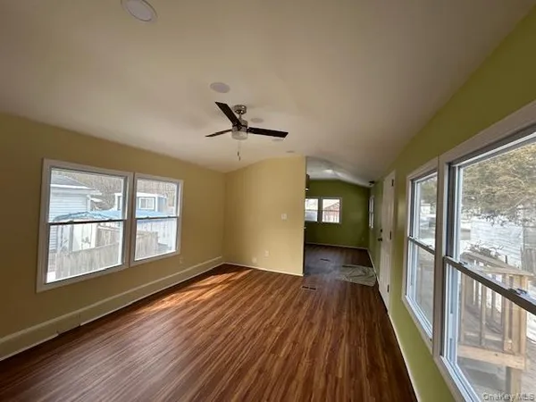 a view of a hallway with wooden floor and stairs
