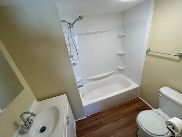 a white toilet sitting next to a bath tub