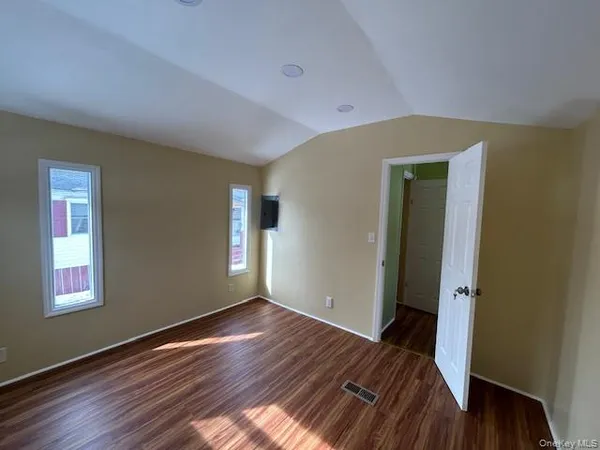 a view of a room with wooden floor and window