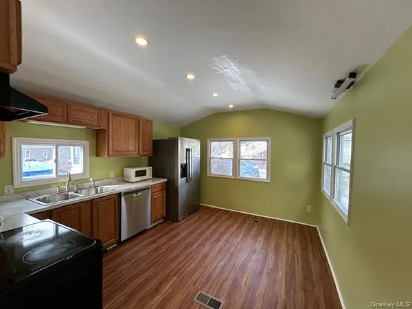 a kitchen with stainless steel appliances granite countertop a stove and a wooden floors