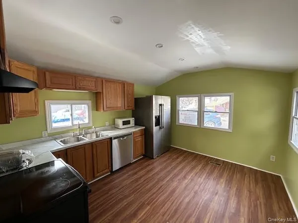 a kitchen with granite countertop a sink window and stainless steel appliances
