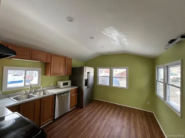 a kitchen with stainless steel appliances granite countertop cabinets wooden floors and a fireplace