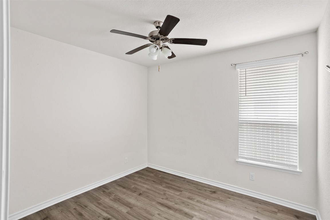 3409 Copper Acres Bulverde, TX 78163 - Photo 17 of 23 an empty room with wooden floor fan and windows