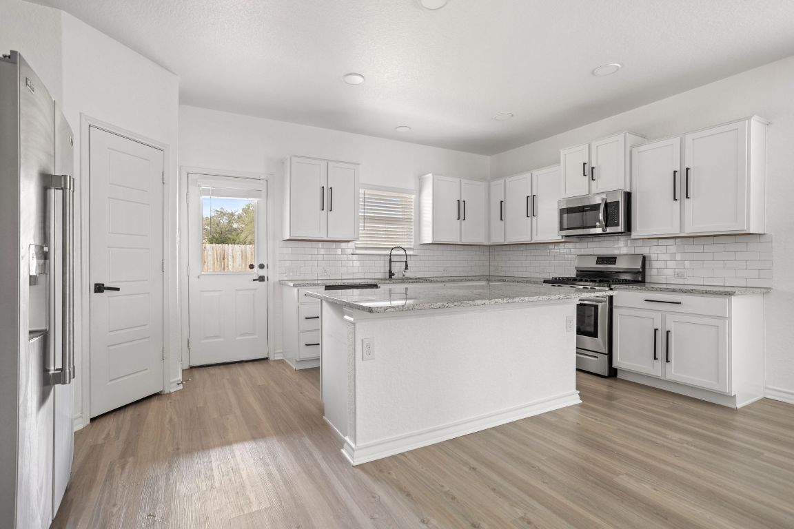 3409 Copper Acres Bulverde, TX 78163 - Photo 8 of 23 a kitchen with granite countertop white cabinets and white appliances