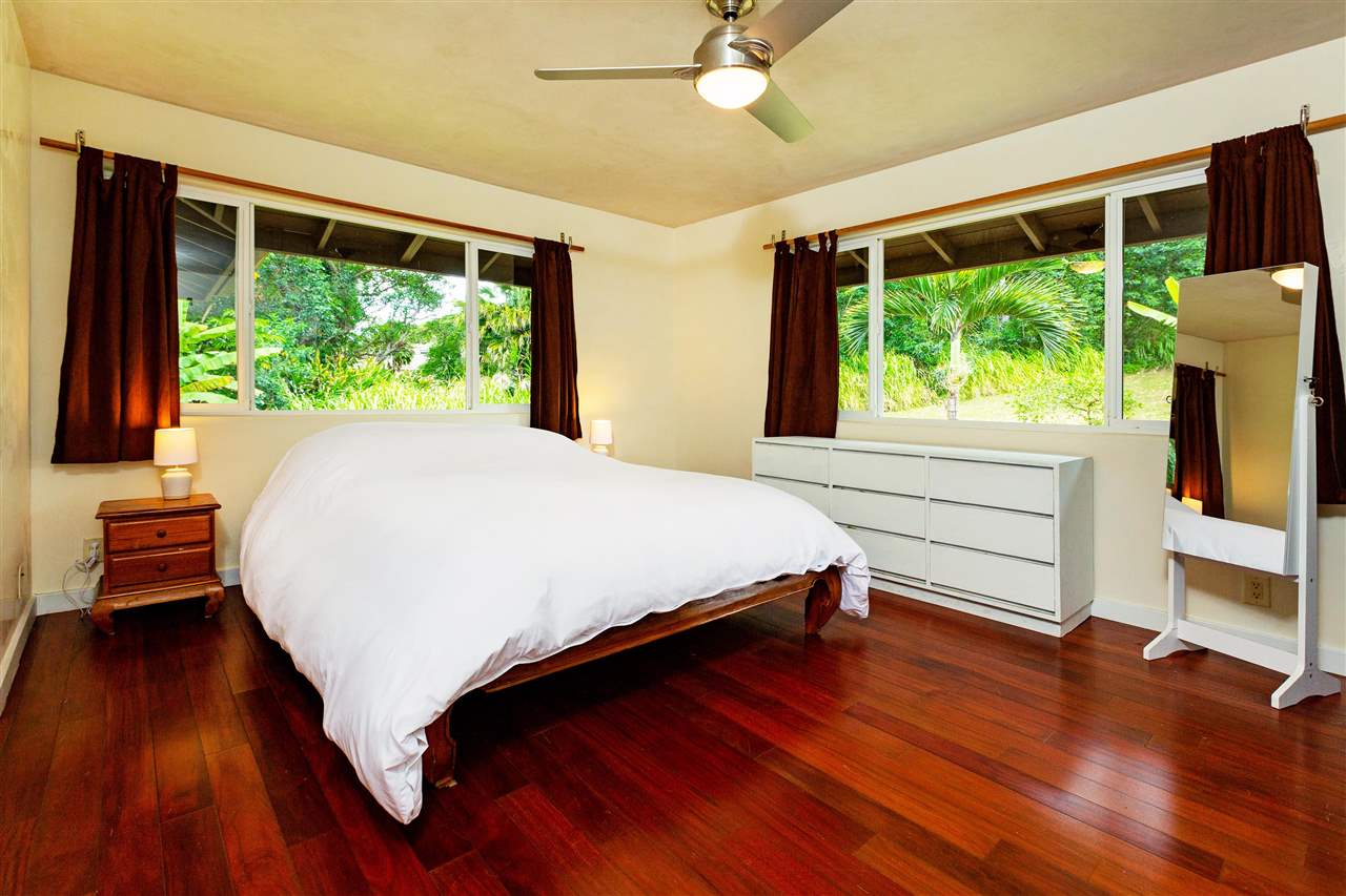 4509 Opana Place Haiku, HI 96708 - Photo 11 of 26 a bedroom with a bed and large windows