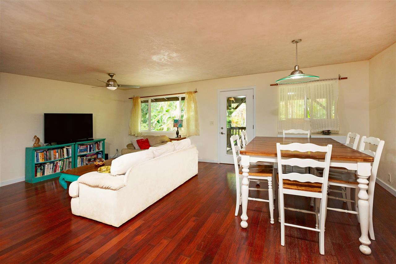 4509 Opana Place Haiku, HI 96708 - Photo 10 of 26 a living room with a dining table wooden floor and a flat screen tv