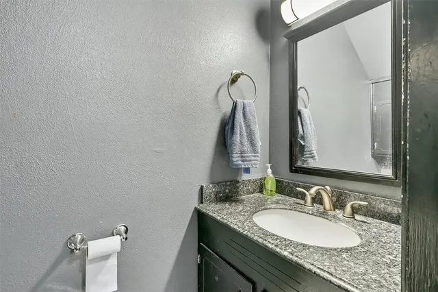 a bathroom with a granite countertop sink and a mirror