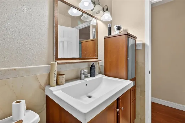 a bathroom with a sink a toilet and a mirror