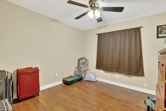a view of room with wooden floor and ceiling fan