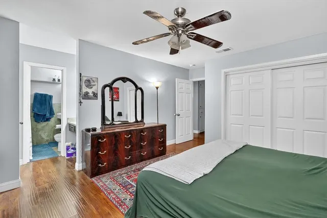 a bedroom with a bed a dresser and mirror