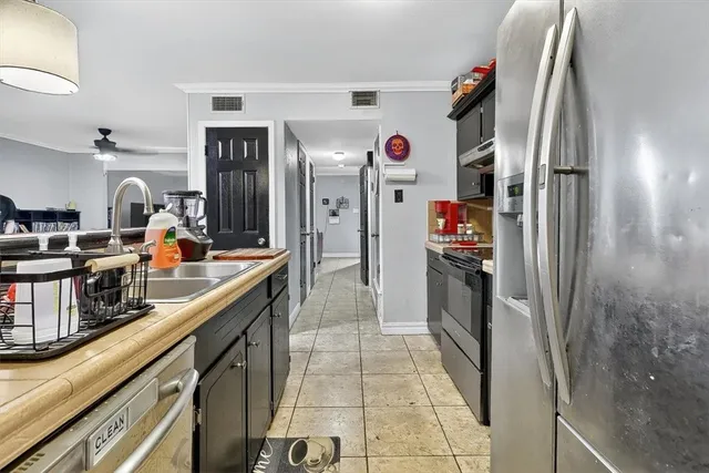 a kitchen with stainless steel appliances granite countertop a refrigerator a stove and a sink