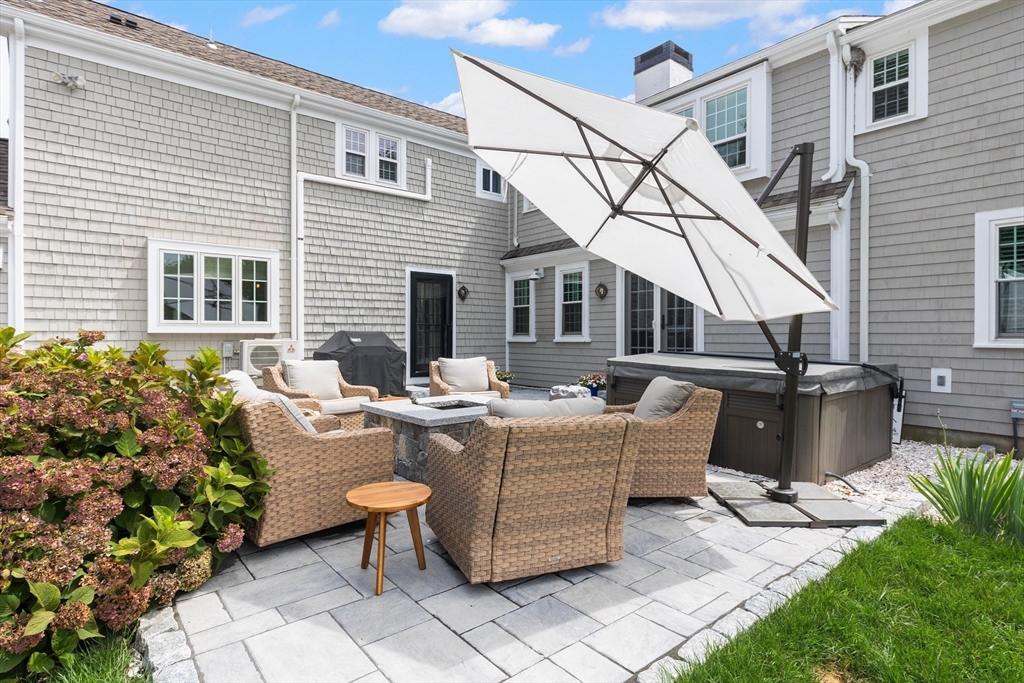17 Common Street Scituate, MA 02066 - Photo 26 of 39 a view of a patio with couches table and chairs under an umbrella