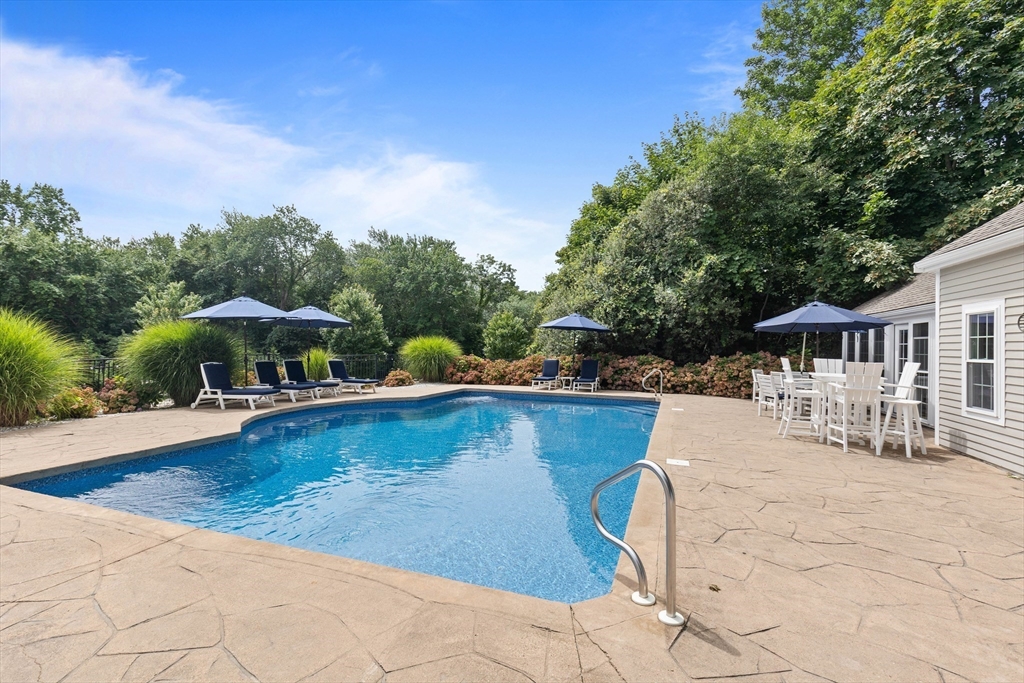 17 Common Street Scituate, MA 02066 - Photo 31 of 39 a view of a swimming pool with a table and chair under an umbrella
