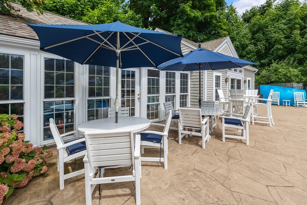 17 Common Street Scituate, MA 02066 - Photo 33 of 39 a blue chair and table sitting in front of a house