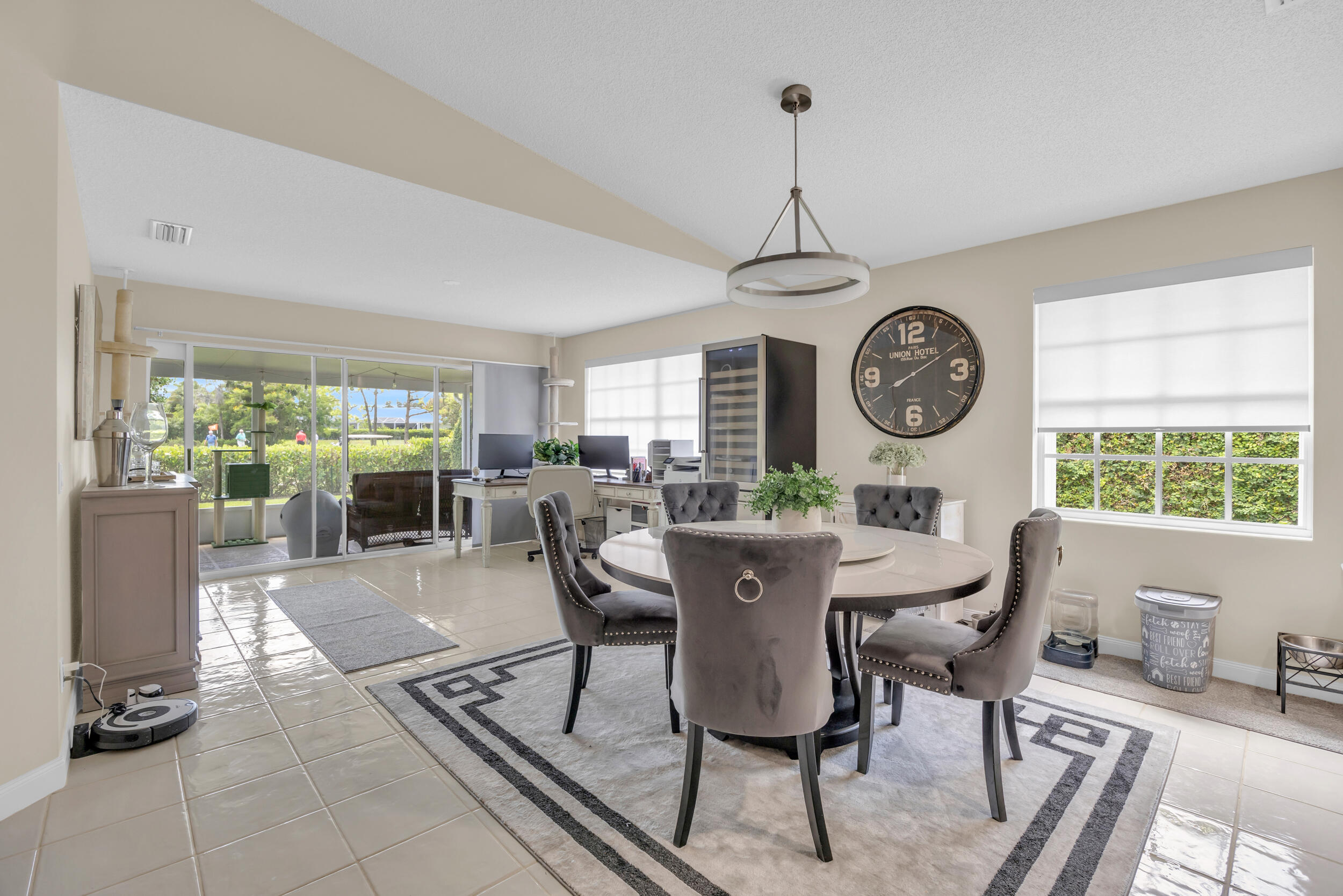 233 Brier Circle Jupiter, FL 33458 - Photo 13 of 31 a view of a dining room and livingroom with furniture large windows a rug and a clock