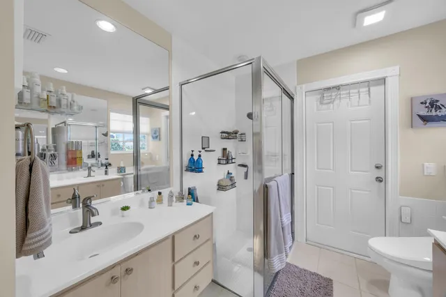a bathroom with a sink double vanity and a shower a mirror