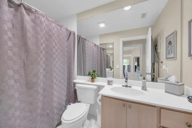 a bathroom with a sink a toilet and shower curtain