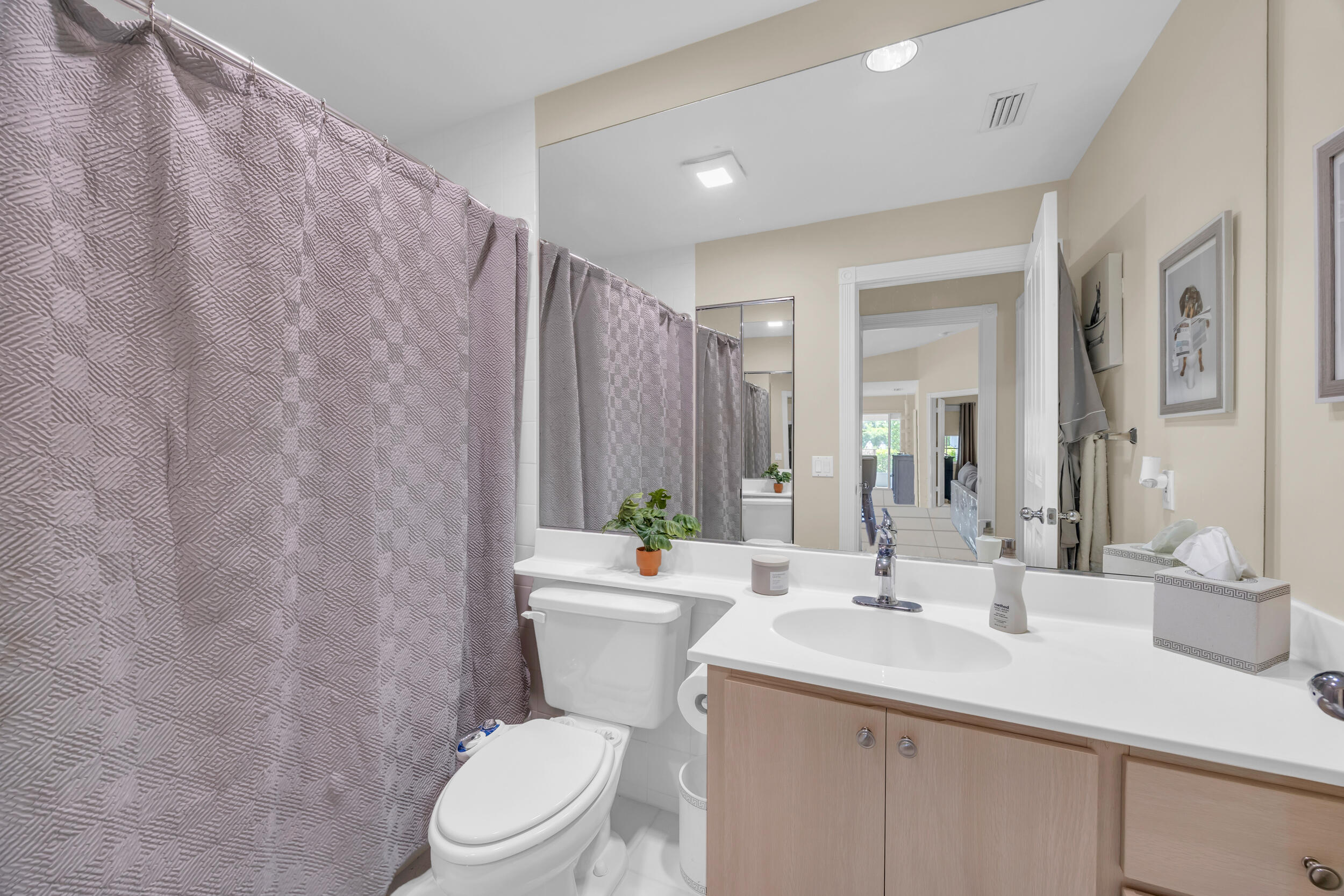 233 Brier Circle Jupiter, FL 33458 - Photo 24 of 31 a bathroom with a sink a toilet and shower curtain