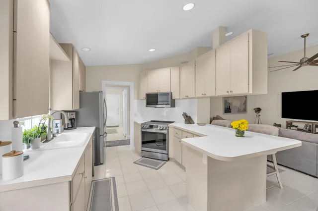 a kitchen with a sink stainless steel appliances and white cabinets
