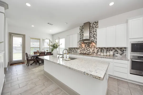 a large living room with stainless steel appliances granite countertop furniture and a fireplace