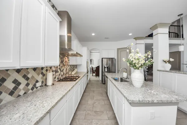 a kitchen with kitchen island granite countertop a sink and a counter top space