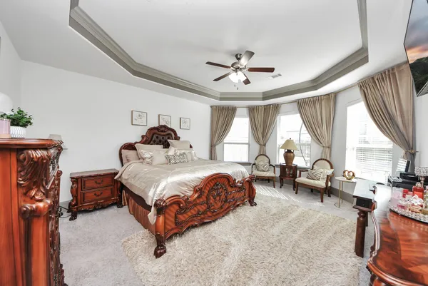 a bedroom with a bed couch and a large window