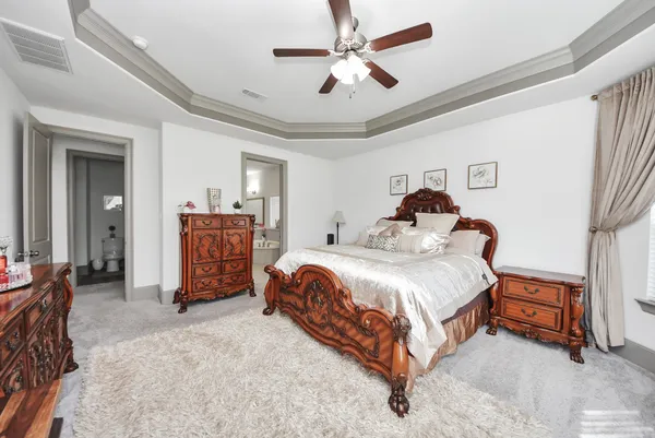 a spacious bedroom with a bed and a chandelier