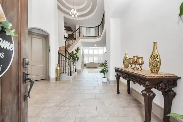 a view of a hallway to room with furniture and wooden floor
