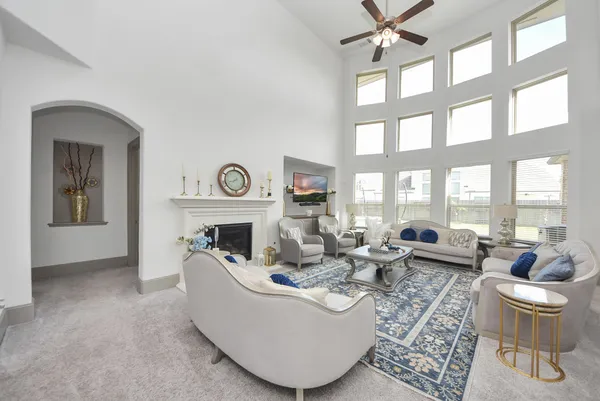 a living room with furniture a fireplace and a large window with garden view