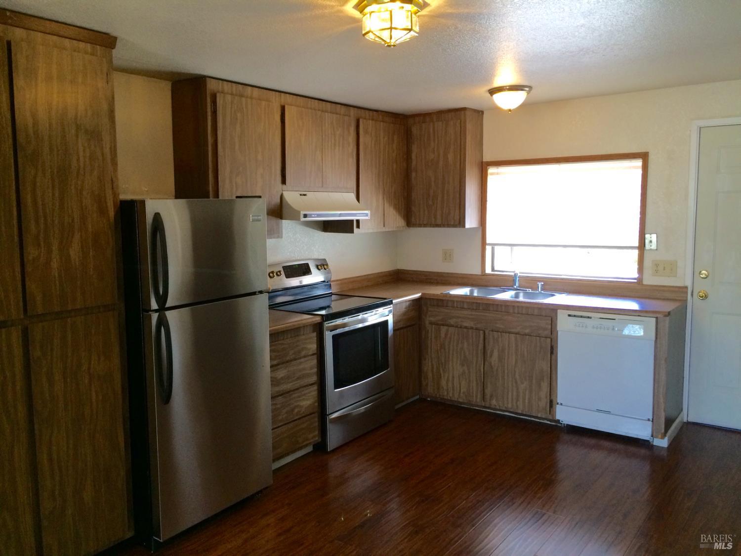 1222 Jacky Drive Santa Rosa, CA 95405 - Photo 13 of 21 a kitchen with granite countertop stainless steel appliances a refrigerator cabinets and a window