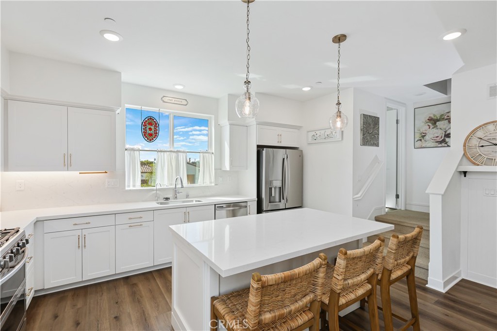 2317 West Broadway, Unit 96 Anaheim, CA 92804 - Photo 11 of 52 a kitchen with a table chairs refrigerator and microwave