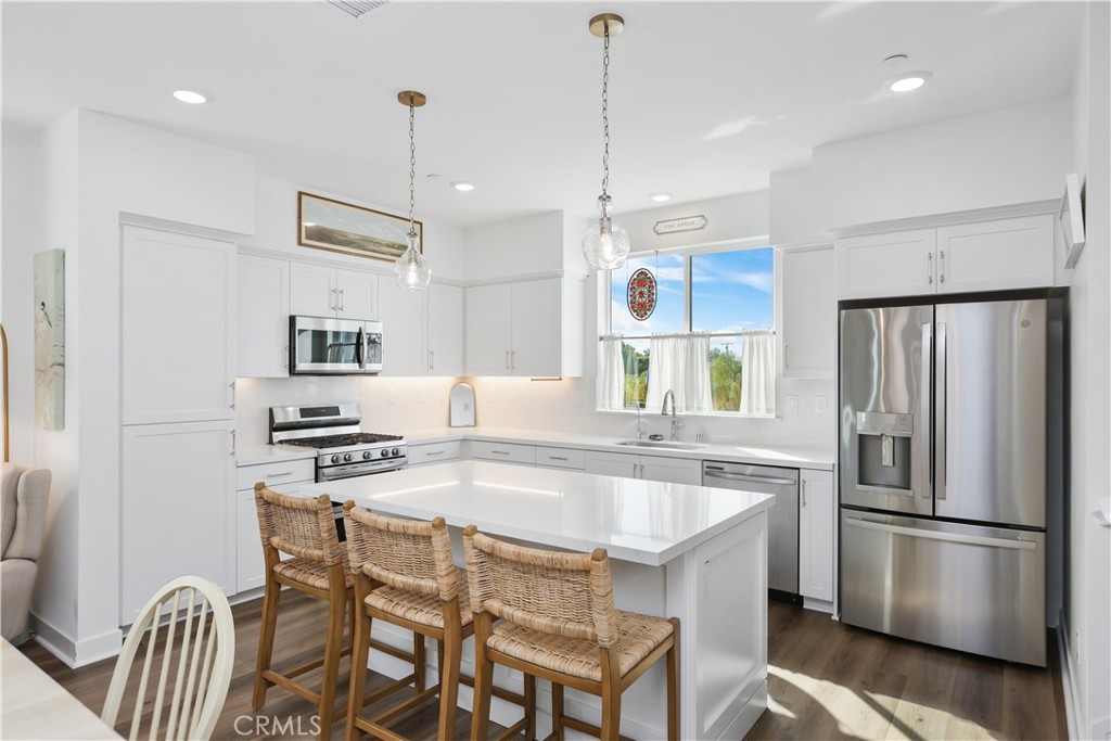 2317 West Broadway, Unit 96 Anaheim, CA 92804 - Photo 12 of 52 a kitchen with stainless steel appliances granite countertop a sink a stove a refrigerator and island with wooden floor