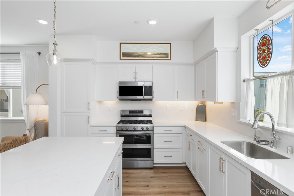 2317 West Broadway, Unit 96 Anaheim, CA 92804 - Photo 13 of 52 a kitchen with stainless steel appliances a stove sink and a microwave