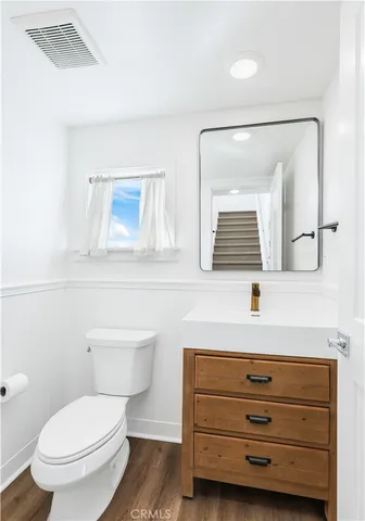 a bathroom with a toilet a sink and mirror