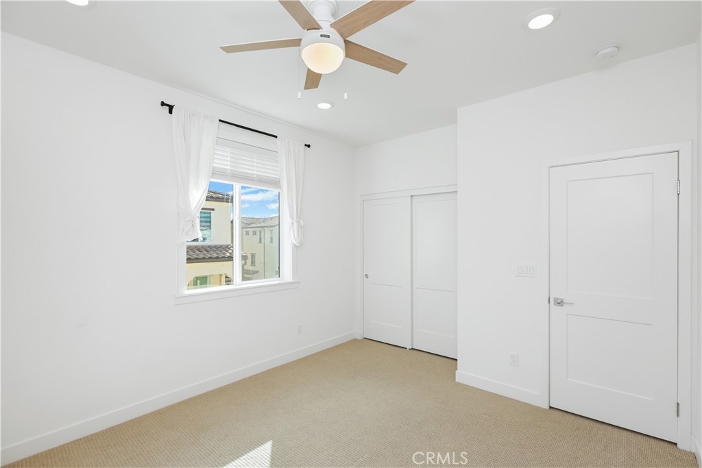 2317 West Broadway, Unit 96 Anaheim, CA 92804 - Photo 22 of 52 an empty room with windows and fan