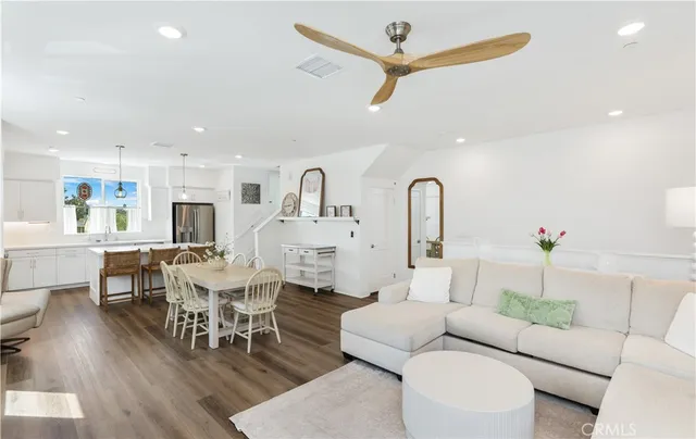 a living room with furniture a rug potted plant and a view of kitchen
