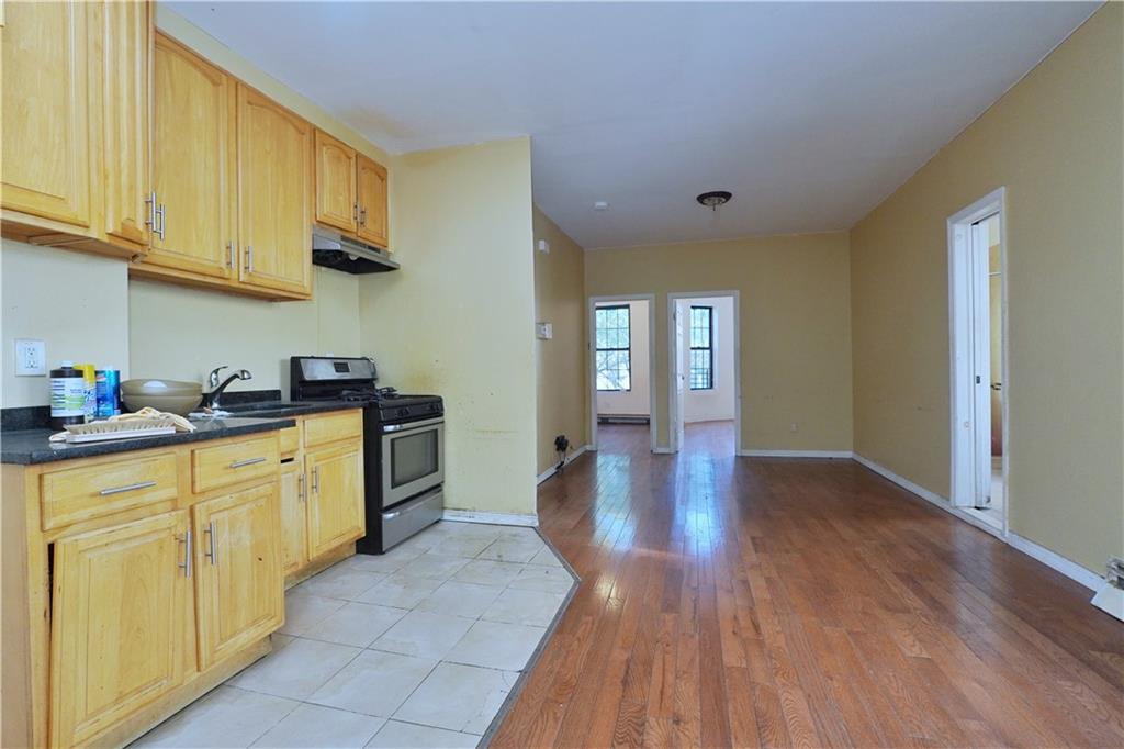 587 Van Siclen Avenue Brooklyn, NY 11207 - Photo 11 of 34 a kitchen with cabinets and wooden floor