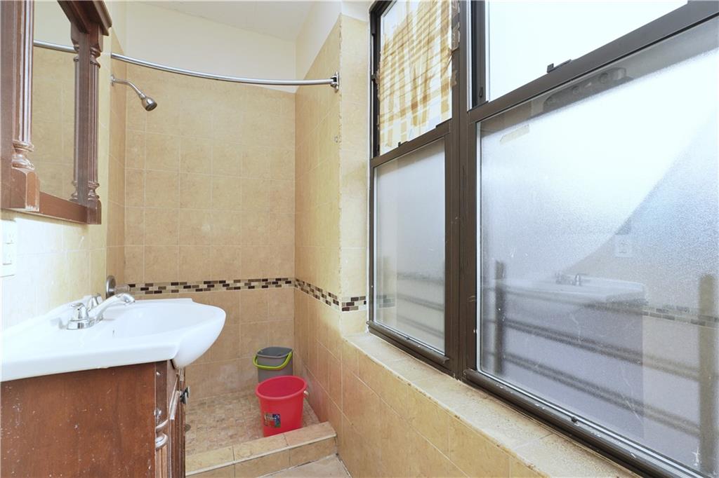 587 Van Siclen Avenue Brooklyn, NY 11207 - Photo 25 of 34 a bathroom with a sink and a mirror