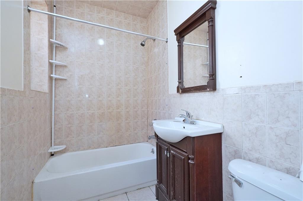 587 Van Siclen Avenue Brooklyn, NY 11207 - Photo 28 of 34 a bathroom with a sink mirror toilet and bathtub