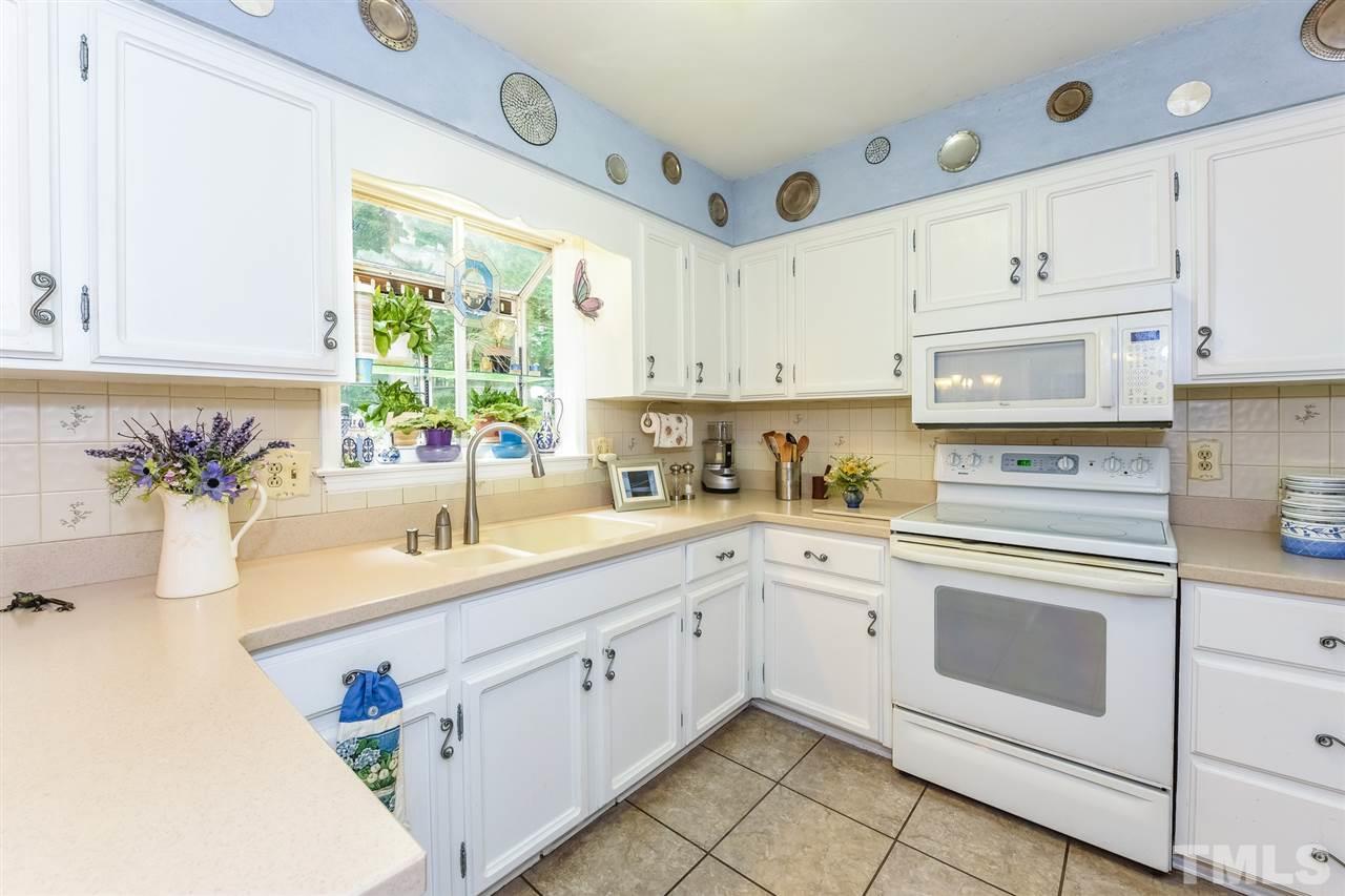 9716 Rock Creek Road Raleigh, NC 27613 - Photo 12 of 25 a kitchen with cabinets appliances a sink and a window