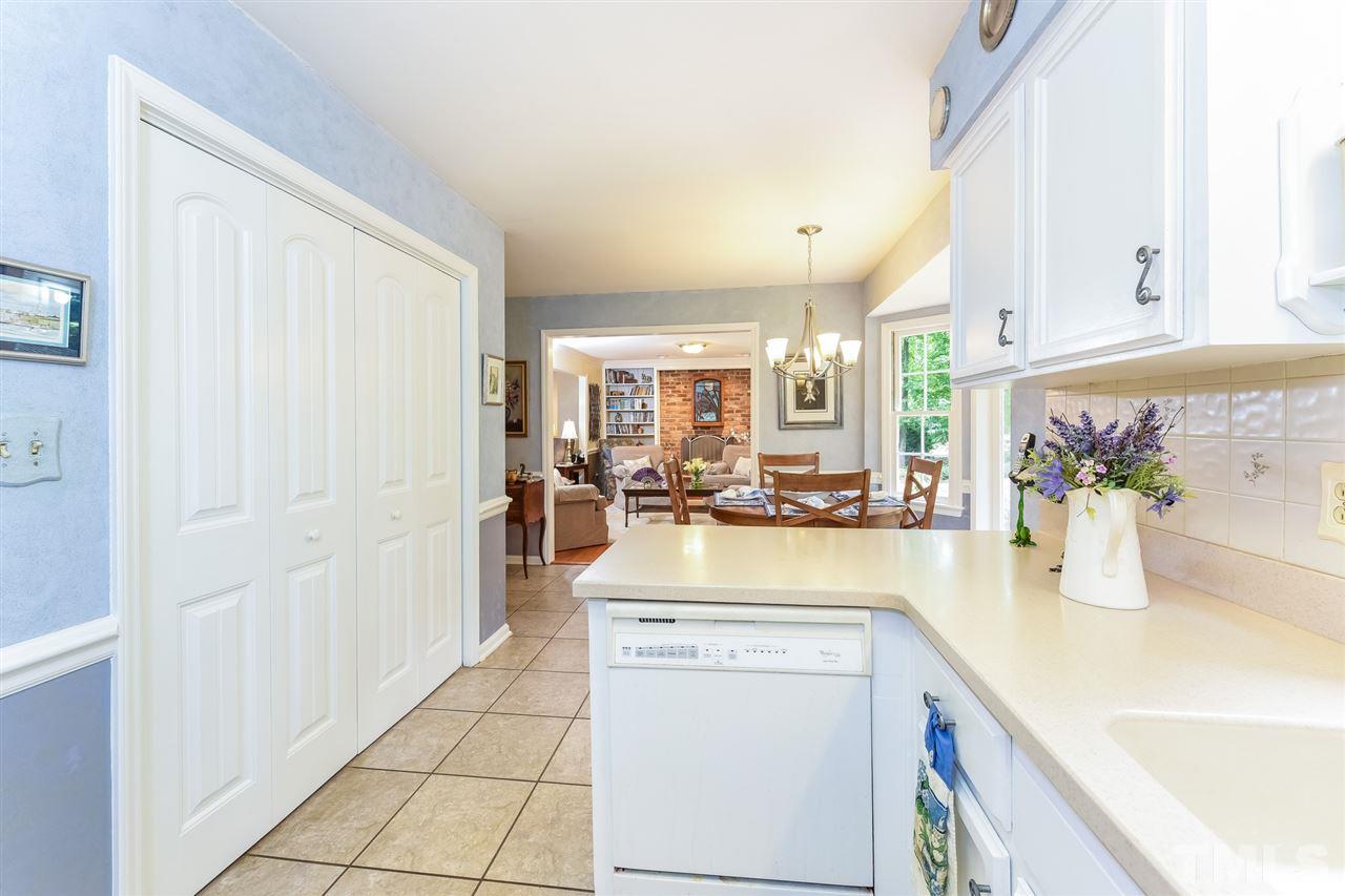 9716 Rock Creek Road Raleigh, NC 27613 - Photo 14 of 25 a view of a kitchen with kitchen island a sink wooden floor and living room view
