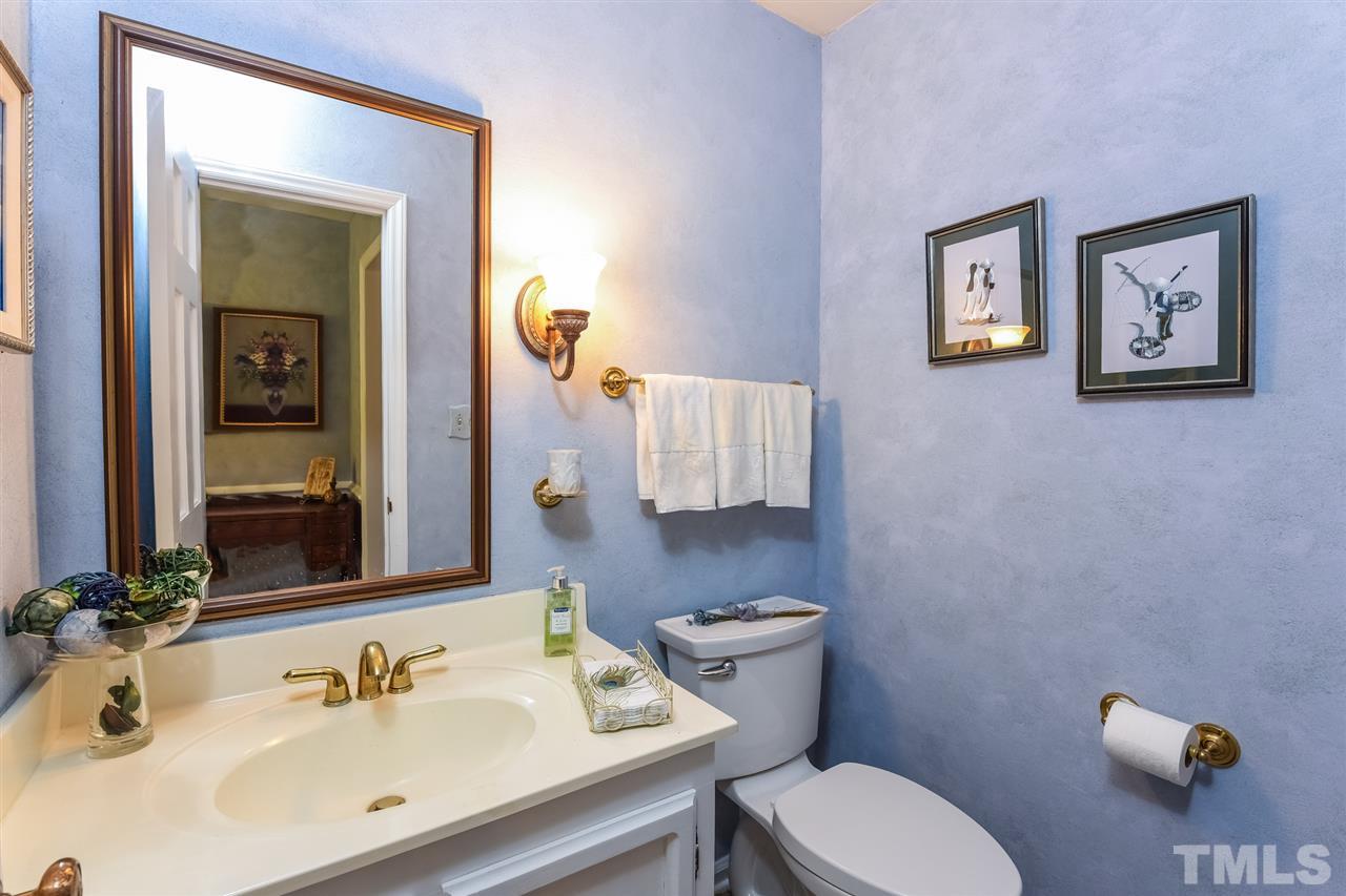 9716 Rock Creek Road Raleigh, NC 27613 - Photo 15 of 25 a bathroom with a sink mirror and toilet