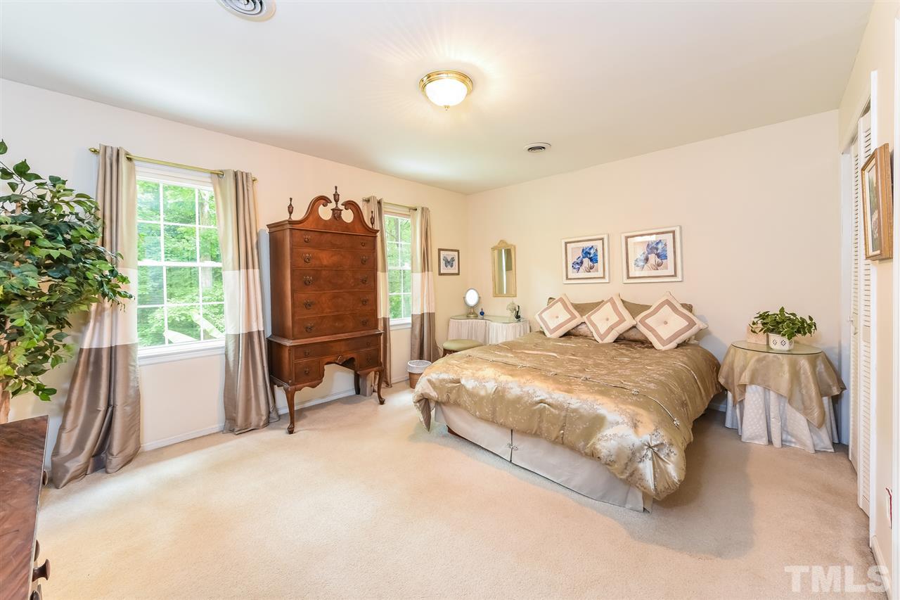 9716 Rock Creek Road Raleigh, NC 27613 - Photo 16 of 25 a spacious bedroom with a bed and glass door