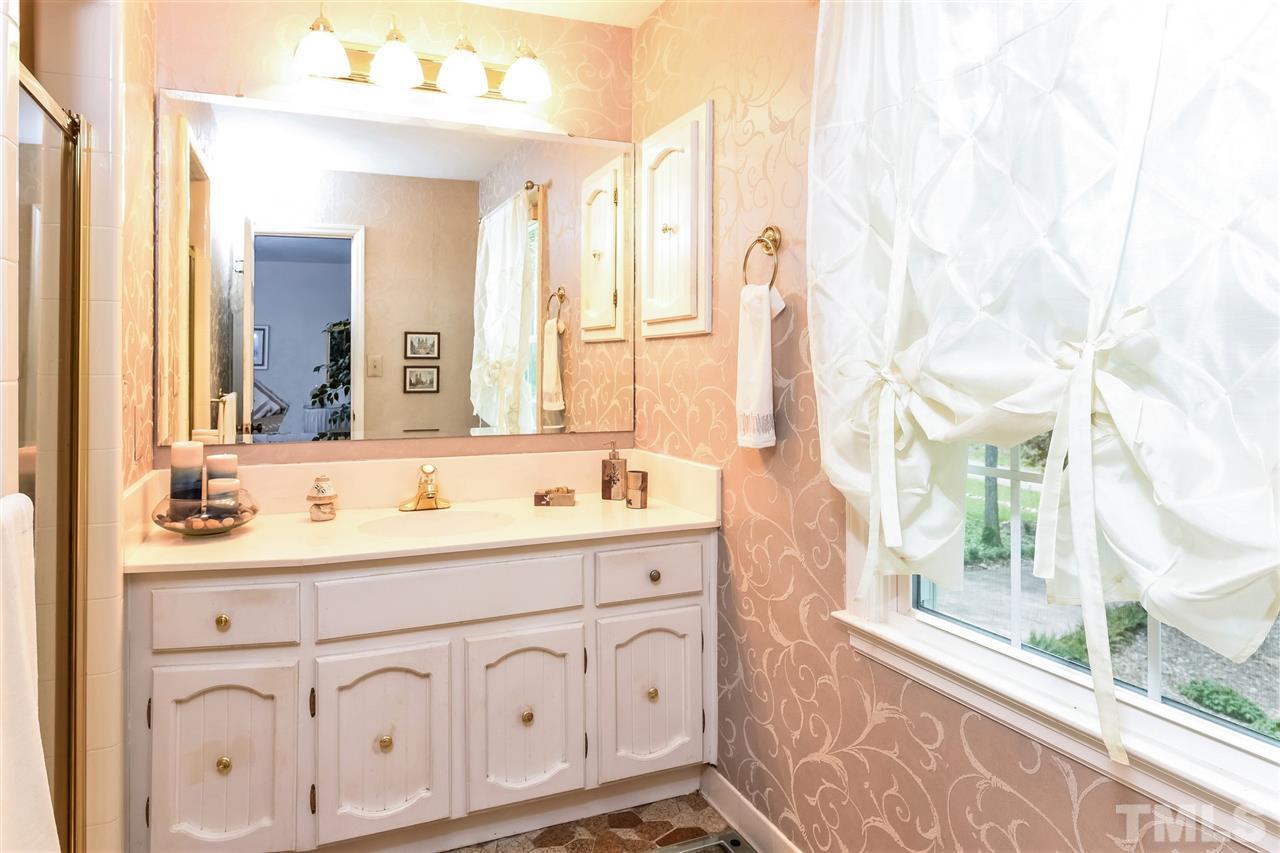 9716 Rock Creek Road Raleigh, NC 27613 - Photo 18 of 25 a bathroom with a double vanity sink a mirror and a